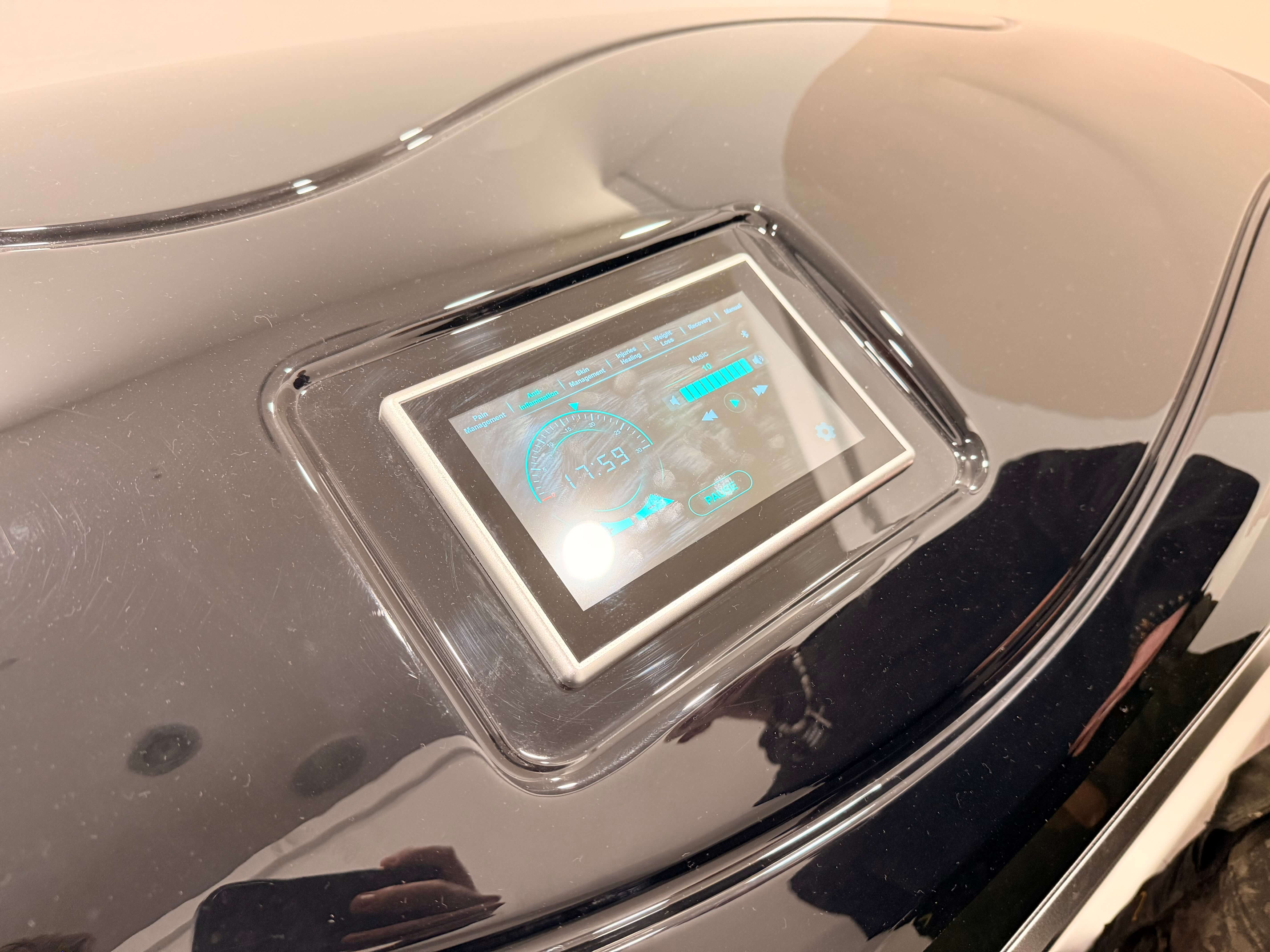 Red light therapy room with illuminated bed and controls